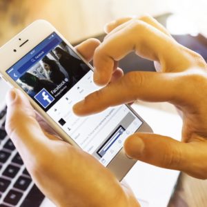 Facebook profile on Apple iPhone 6s Istanbul, Turkey - January 13, 2016: Person holding a brand new Apple iPhone 6s with Facebook profile on the screen. Facebook is a social media online service for microblogging and networking, founded in February 4, 2004.